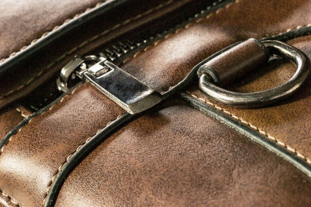 Close-up of a zip fastener with a lock on a leather product