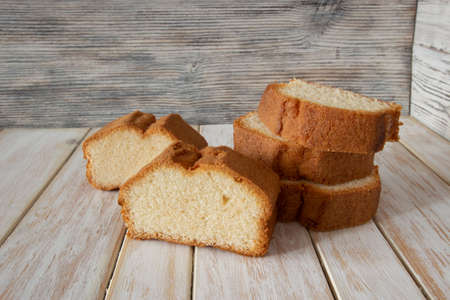 Slices of delicious sponge cake on wooden backgroundの写真素材