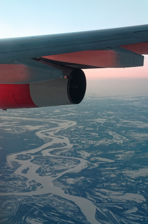 Airplane wing over beautiful winter landscape. Somewhere over North of Russiaの写真素材