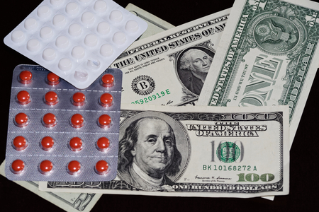 Pills in blister packaging and american dollars on black backgroundの写真素材