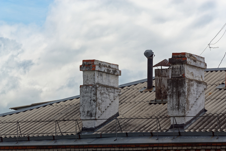Two old chimneys the roof of an apartment house, Komsomolsk-on-Amure, Russiaの写真素材