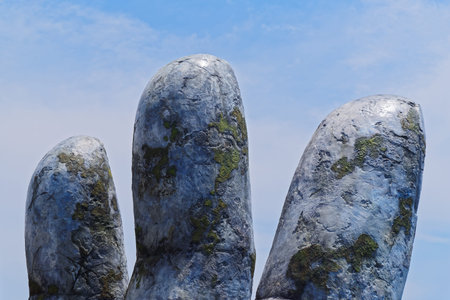 Da Nang, Vietnam - May 6, 2019: Stone fingers against blue cloudy sky. This fingers are from the...