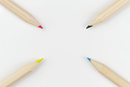 Four colored pencils on a white background arranged as a targetの写真素材