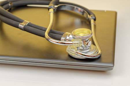 High angle view of stethoscope lying on closed notebook