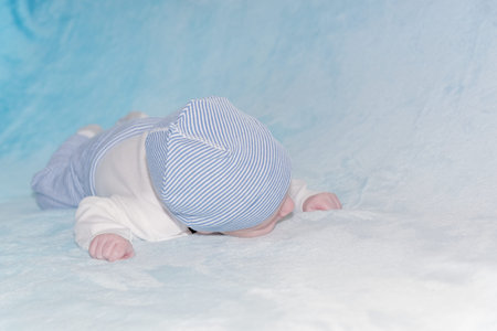 Close-up of 2 months old infant lying on their tummy and sleeping
