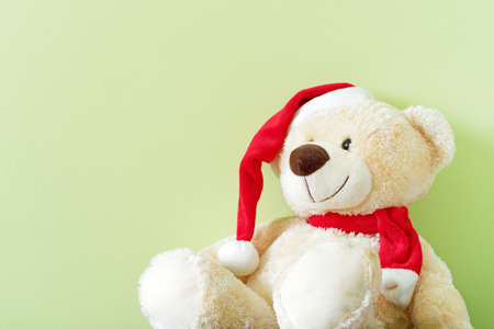 Teddy bear with red christmas cap against light green backgroundの写真素材