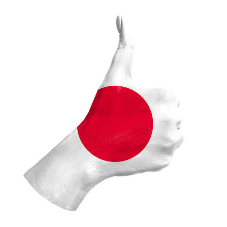 Hand with thumb up paint in colors of Japan national flag isolated on white background. Symbol of like excellence, achievement, - for tourism, political, social management, sports, championshipの写真素材