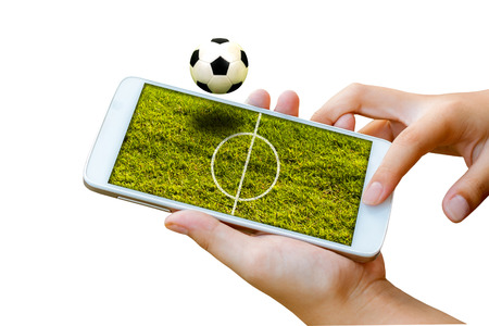 man hand hold and touch screen smart phone, tablet,cellphone isolated on white with football field on screen ,abstract background to sport football or soccer online gambling.の写真素材