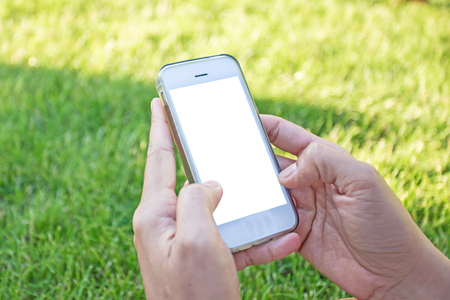 woman hand hold and touch screen smart phone,tablet,cellphone over blurred green yard background,Image for Advertising online Application Solution or Mobile banking Concept.の写真素材