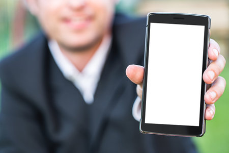 Smart phone with blank space on Hand of Caucasian Business Man holding Cellphone over Blurred garden...