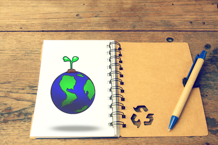 globe with recycle notebook and pen on wooden background,vintage color tone. earth day concept.の写真素材