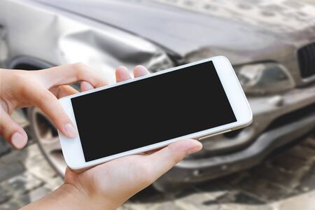 woman hand hold and touch screen smart phone or cellphone over blurred of car accident background.の写真素材
