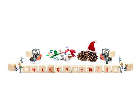 Miniature worker with wood block and pine cone , euro banknote isolated on white background ,  Image for Christmas Holiday and Happy New Year Gift Celebration concept.の写真素材