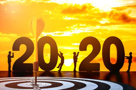 old dart target with arrows over silhouette worker people and 2020 text.の写真素材