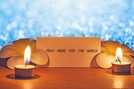 still life candle with flower and note pray for the world  background,candle flame at night.の写真素材