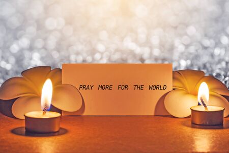still life candle with flower and note pray for the world  background,candle flame at night.の写真素材