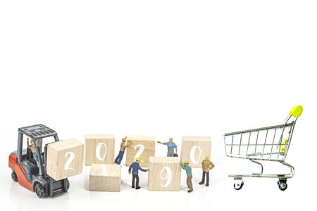 miniature worker team building standing front of forklift machine with white 2020 number on wooden block on white background, decoration to Happy new year 2020 concept.の写真素材