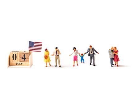 selective focus of miniature people , couple , and family  with United State flag isolated on white background, creative image for 4 July independent day celebrate concept.の写真素材