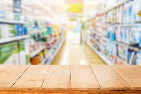 wooden table or wooden mock up over blurred supermarket background.の写真素材