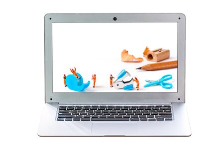 laptop or notebook with miniature worker and stationary tool isolated on white background for advertisement showcase or advertising marketing concept.の写真素材