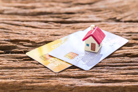 demo credit card and miniature home on wooden backgroundの写真素材