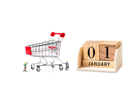 worker with shopping cart and wooden calendar with 1 january word.の写真素材
