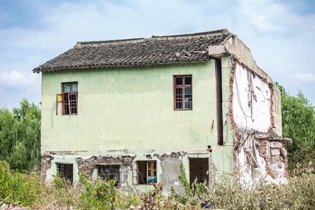View of a decaying house in the middle of an overgrown garden.の写真素材