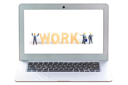 Miniature people: Businessman standing on laptop with work word on screenの写真素材