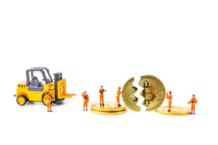 Miniature people worker with forklift and bitcoin coin on white background.の写真素材