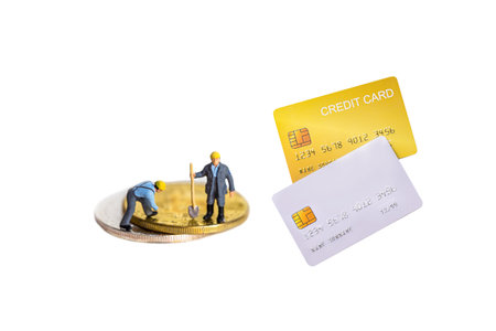 Miniature worker and gold coin with demo credit card on white background.の写真素材