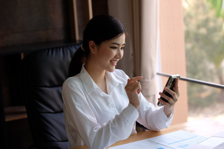 business woman using smart phone in the office, business and technology conceptの写真素材