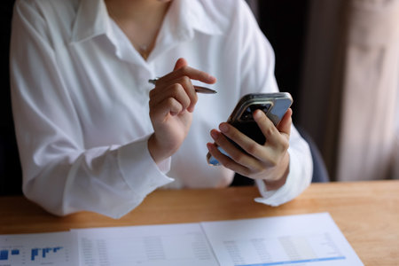 Close up of businesswoman using smart phone in office. Business concept.の写真素材
