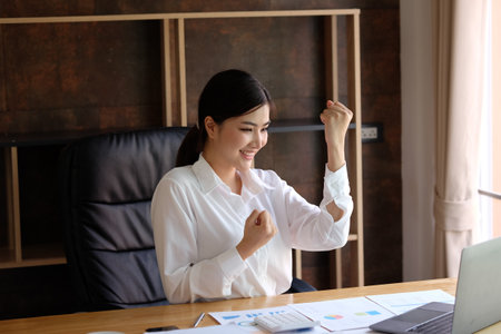 Successful businesswoman working with laptop computer in modern office room.の写真素材