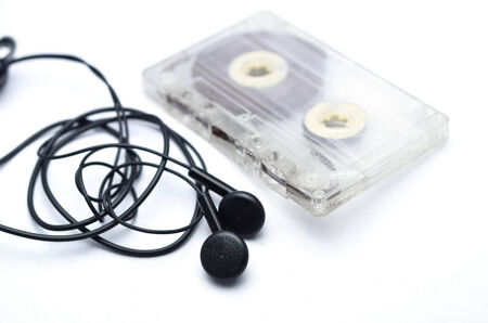 Earphones and cassette on a white background の写真素材