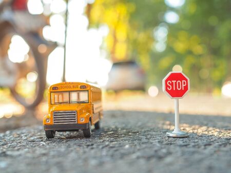 yellow school bus plastic and metal toy model on the country roadの写真素材