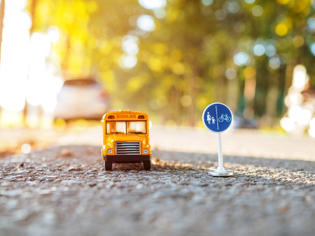yellow school bus plastic and metal toy model on the country roadの写真素材
