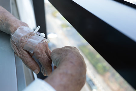 Close-up of an old woman's hands using a hand sanitizerの写真素材