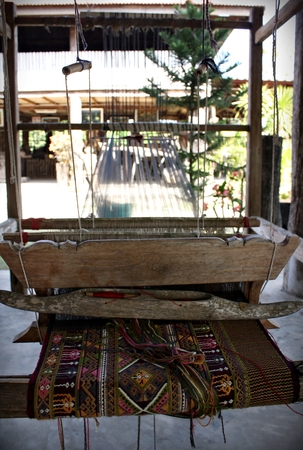 An old-style loom producing a colorful cloth in Thailandのeditorial素材
