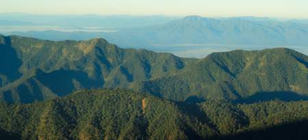 landscape layer mountain with foggy in winter season and gold lightの写真素材