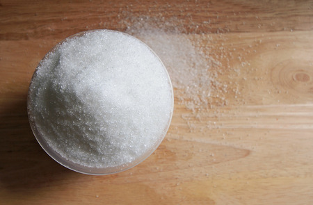 sugar in a cup on wood table backgroundの写真素材