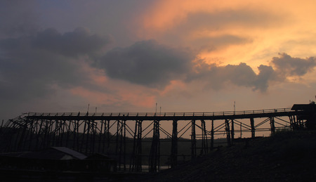 Kanchanaburi- April 26 :  tourist is on old bridge and the sunlight fall with a mountain background at Sangklaburi on April 26, 2014 Kanchanaburi Thailand.のeditorial素材