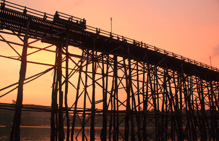 Kanchanaburi- April 26 :  tourist is on old bridge and the sunlight fall with a mountain background at Sangklaburi on April 26, 2014 Kanchanaburi Thailand.のeditorial素材