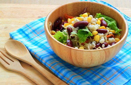 Healthy salad with fresh vegetables on wood backgroundの写真素材