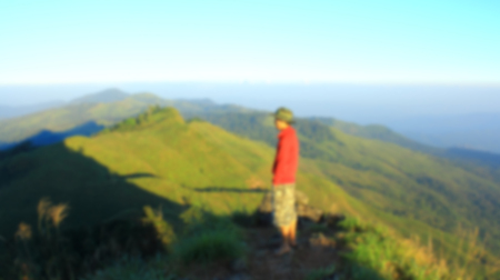Man on top of mountain,blurred for presentation effect, abstract backgroundの写真素材