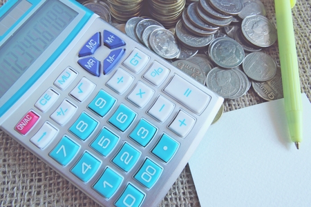 Business concept. Counting money on calculator, stack of coins. Financial Accounting - money and calculator.の写真素材