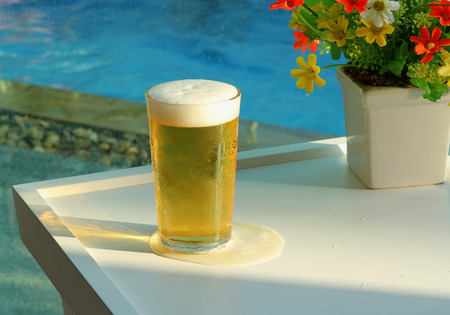 Beer mugs by swimming pool in tropical resortの写真素材