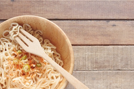wood bowl of noodles with spices on wooden tableの写真素材