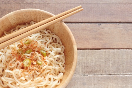 wood bowl of noodles with spices on wooden tableの写真素材