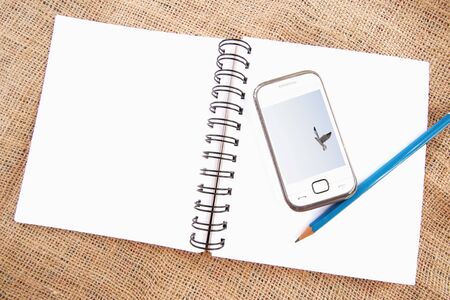 Open notebook with mobile phoneの写真素材