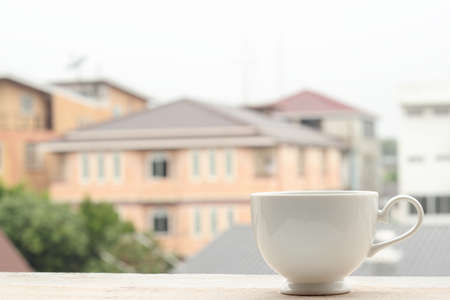 Coffee cup on blurred city backgroundの写真素材